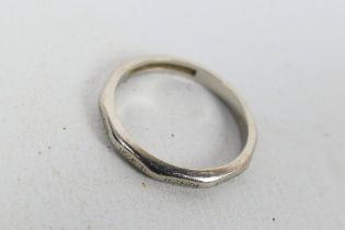 A white metal band ring, stamped AW PLATINUM 97%, size J+½, approximately 3.