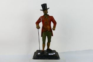 A vintage cast metal, polychrome figure depicting a gentleman in early 19th century dress,