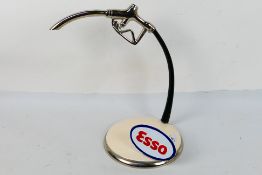 A chrome model of a petrol pump nozzle with cast metal ESSO plaque to the base, 33 cm (h).