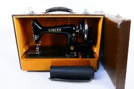 A vintage Singer sewing machine contained in carry case.