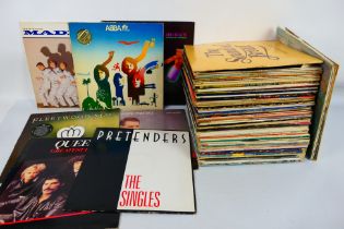 A collection of 12" vinyl records to include Gary Numan, Fleetwood Mac, ABBA, Madness, Queen,