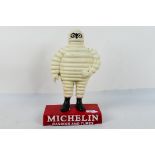 A cast iron advertising piece for Michelin Casing And Tubes featuring a standing Bibendum,