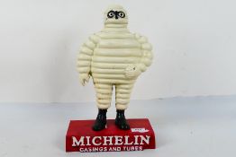 A cast iron advertising piece for Michelin Casing And Tubes featuring a standing Bibendum,
