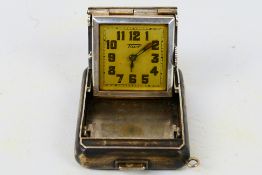 A white metal cased Tissot purse clock, the signed square dial with Arabic numerals, case stamped 0.