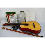 A Kent acoustic guitar contained in case and a carved wood walking stick. [2].