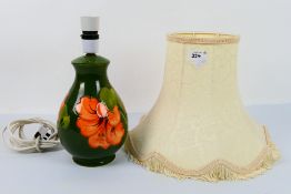 Moorcroft Pottery - A table lamp decorated in the Hibiscus pattern, reserved against a green ground,