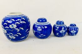 A collection of blue and white ginger jars (three with covers), decorated with prunus,