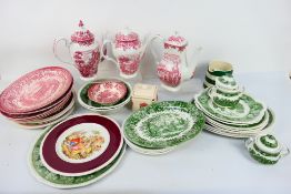A collection of ironstone dinner and tea wares in red and white and green and white.