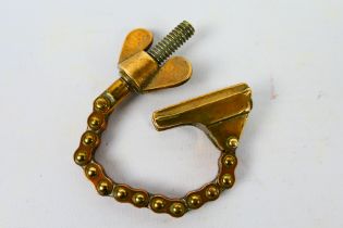 An unusual bottle opener formed from a chain and wingnut, possibly a trench art piece.