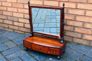 A late 19th or early 20th century toilet mirror, the bow front base having three drawers,