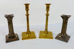 Two pairs of candlesticks comprising a pair of silver plated Corinthian column examples and a brass