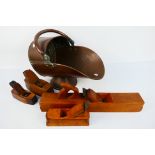 A copper coal scuttle and four vintage wooden woodworking planes.