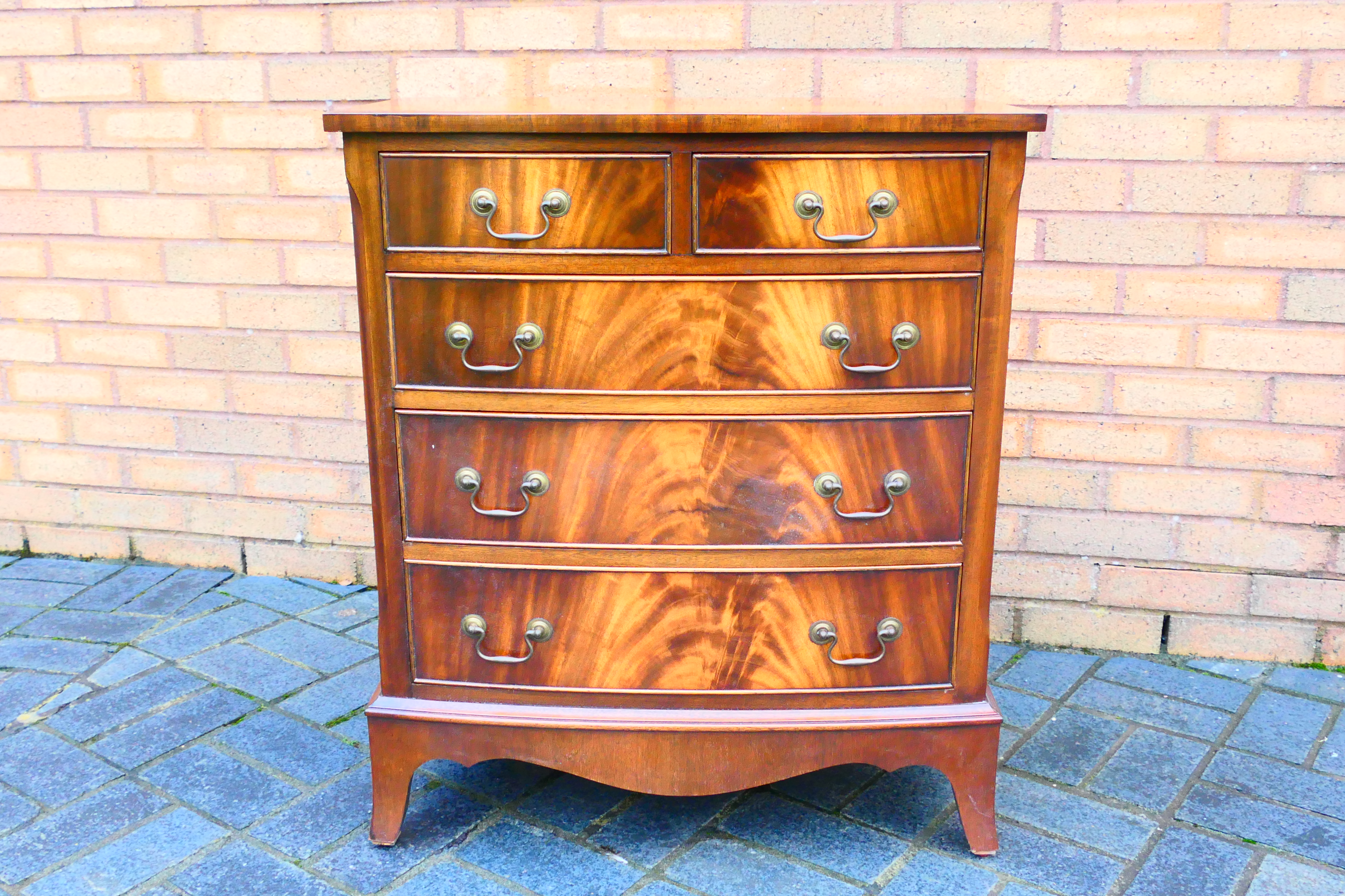 A bow front chest of two over three drawers, raised on outswept supports,