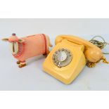 A vintage dial telephone and a money bank in the form of a sheep.