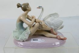 A Lladro figural group # 6204, Grace And Beauty, depicting a seated ballerina and a swan,