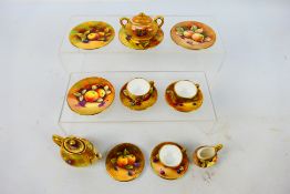 A collection of miniature Coalport tea wares decorated with fruit comprising teapot, sugar bowl,