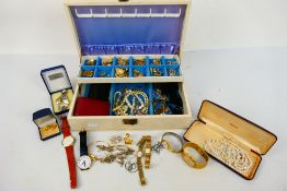 A jewellery box containing a quantity of costume jewellery and watches.