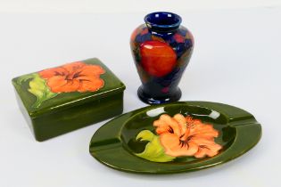 Moorcroft Pottery - Three pieces comprising a small vase decorated in the Pomegranate pattern (chip