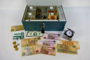 A small quantity of predominantly foreign coins and bank notes contained in a locking cash tin.