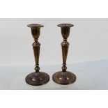 A pair of George V silver candlesticks (weighted), the fluted stems rising from a circular foot,