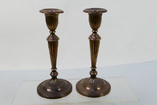 A pair of George V silver candlesticks (weighted), the fluted stems rising from a circular foot,