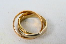 Three interlocking gold rings of which one stamped .