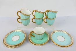 A set of seven Royal Crown derby gilt and pale blue ground, fluted coffee cups and saucers,