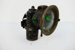 A Joseph Lucas Calcia Cadet acetylene or carbide bicycle lamp with 2¾" clear convex lens and green