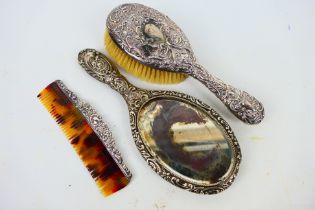 Three late Victorian silver backed dressing table items comprising hand mirror, brush and comb,