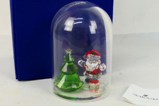 Swarovski - A boxed crystal figure group of Father Christmas,