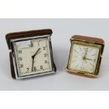 A Smiths Art Deco travel alarm clock in folding leather case, one further travel alarm clock.