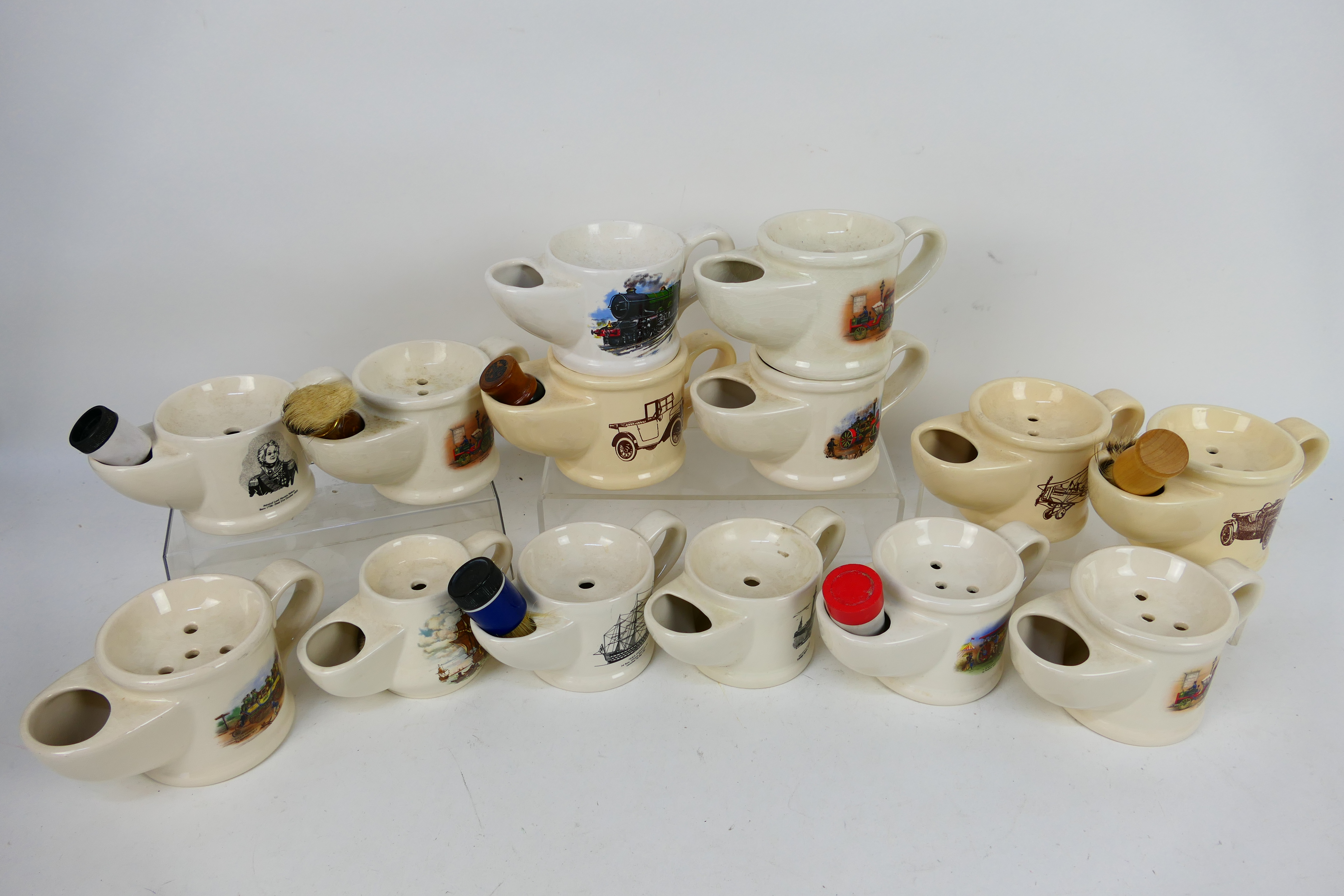 A collection of vintage shaving mugs, predominantly Wade, with images of trains, ships,