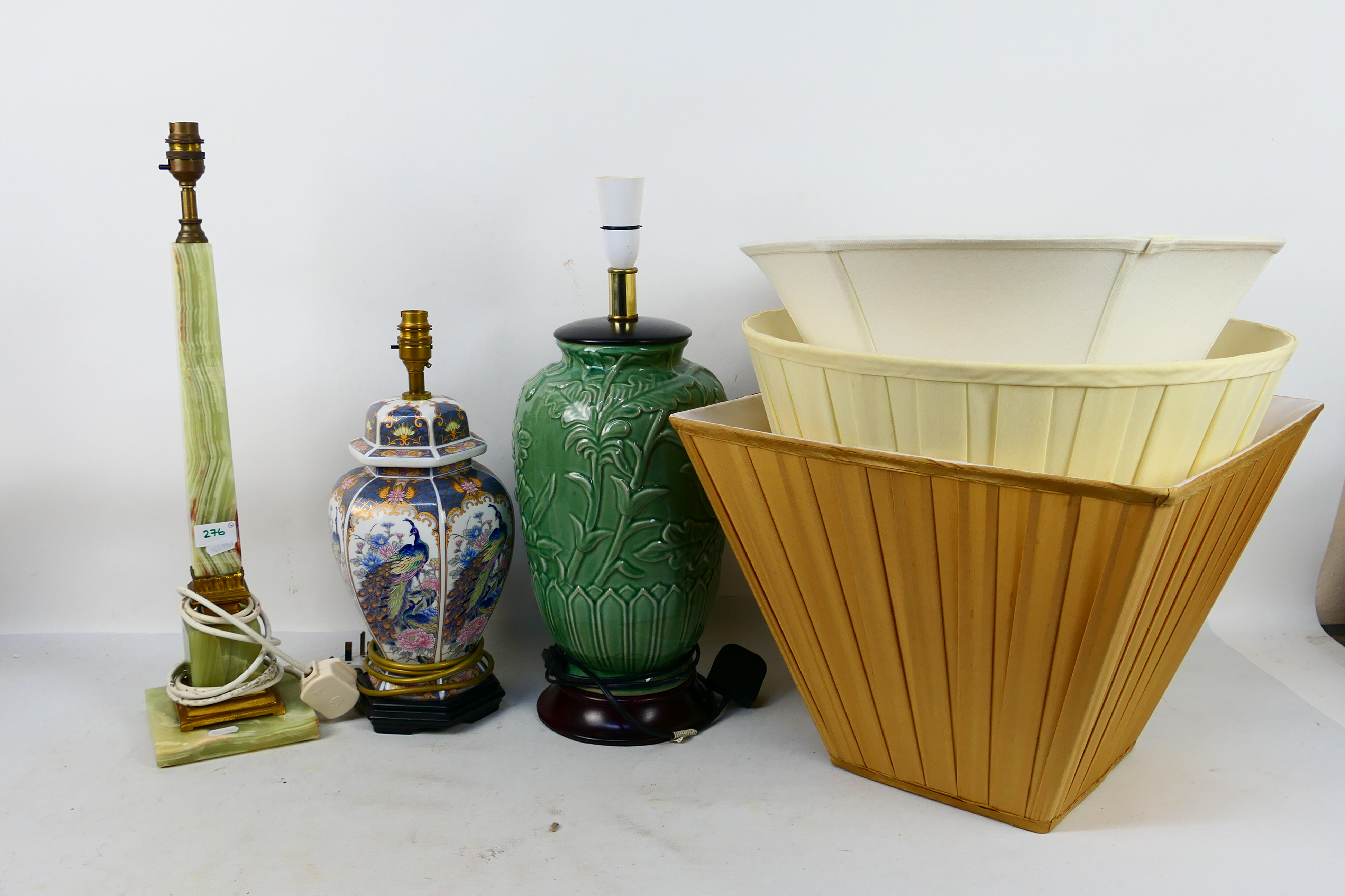 Three table lamps and shades to include a tall green onyx and brass example.