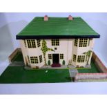 Tri-ang - A vintage wood and metal two storey six room dolls house with a walled garden base and