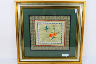 A Chinese embroidery on silk depicting flowers and an insect, framed under glass,