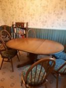 Ercol - An Ercol circular topped extending dining table and six Quaker dining chairs,