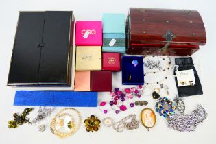 A jewellery casket containing a quantity of costume jewellery to include necklaces,