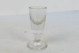 A Toastmasters firing or dram glass, round funnel bowl on cylindrical stem, approximately 9 cm (h).