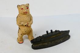 Two money banks comprising a cast iron example in the form of a standing bear,