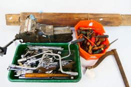 A quantity of tools to include hammers, jack handles, flat-head screw drivers, vintage vice,