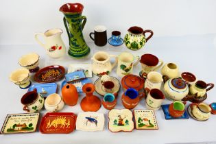 A collection of Torquay pottery wares to include bowls, jugs, vases,