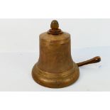 A cast brass bell with cast iron clapper, approximately 27 cm (h).