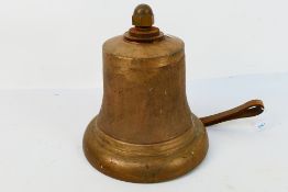 A cast brass bell with cast iron clapper, approximately 27 cm (h).