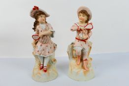 A pair of bisque figures depicting a boy