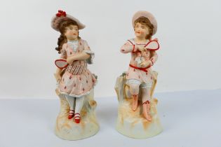 A pair of bisque figures depicting a boy