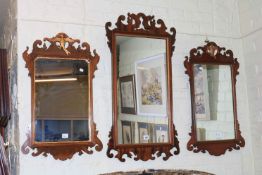 Three mahogany fretwork wall mirrors, including two with Phoenix crest.