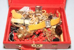 Small red case with jewellery and watches.