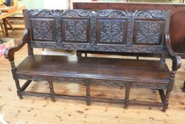 Jacobean style oak quadruple carved panel back open arm bench, 104cm by 182cm.