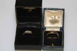 Three stone diamond ring, size T and 9 carat gold wedding band (2).