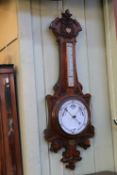 Carved oak barometer with enamelled dial.